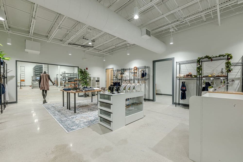 Modern retail store interior featuring clothing displays, shelves, and minimalist design.