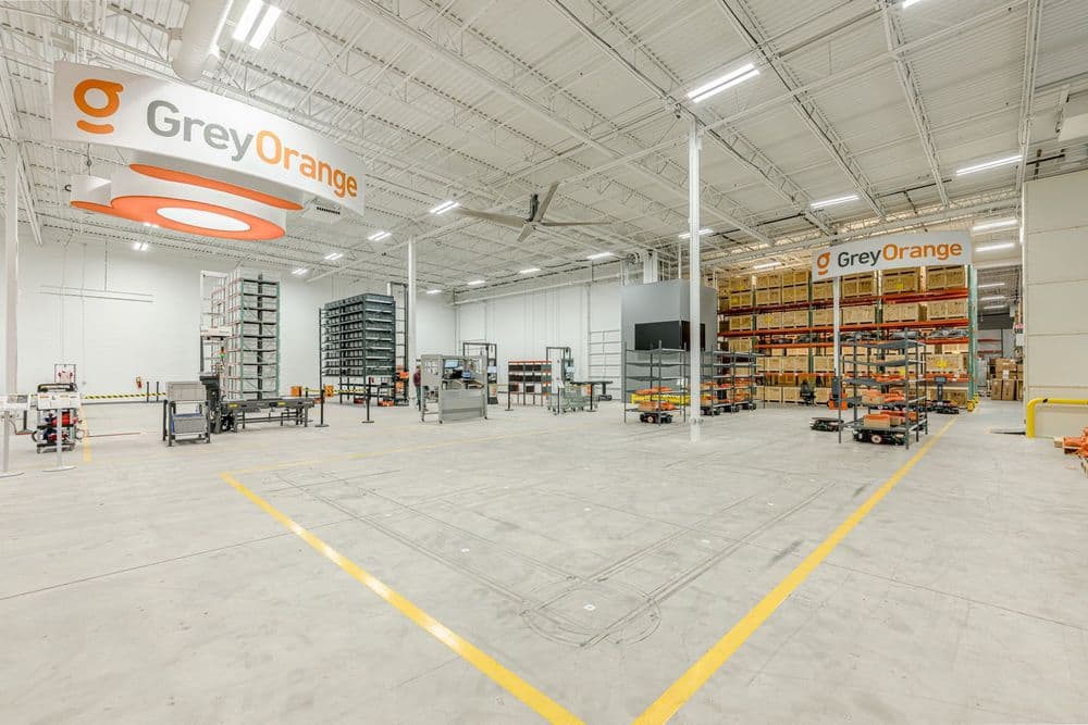 GreyOrange warehouse interior with organized shelving and modern automation equipment.